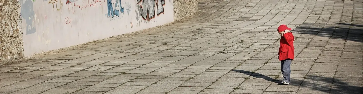 Chłopiec spacerujący po chodniku