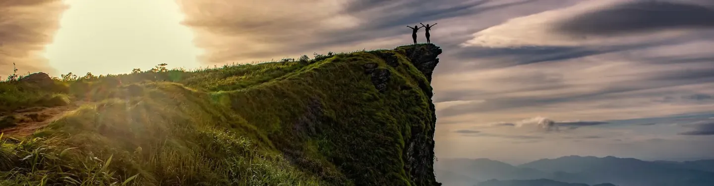 Dwie postacie stojące na szycie wzgórza